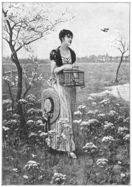 A young woman walking in the countryside and releasing two birds from a cage