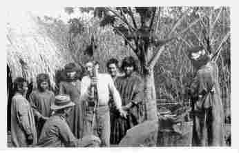 Fig. 22—Trading with Machiganga Indians in a reed swamp at Santao Anato, Urubamba Valley, before Rosalina. Just outside the picture on the right is a platform on which corn is stored for protection against rodents and mildew. On the left is the corner of a grass-thatched cane hut.