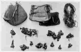 Fig. 23—Ornaments and fabrics of the Machiganga Indians at Yavero. The nuts are made up into strings, pendants, and heavy necklaces. To the left of the center is one that contains feathers and four drumsticks of a bird about the size of a small wild turkey—probably the so-called turkey inhabiting the eastern mountain valleys and the adjacent border of the plains, and hunted as an important source of food. The cord in the upper right-hand corner is used most commonly for heel supports in climbing trees. The openwork sack is convenient for carrying game, fish, and fruit; the finely woven sacks are used for carrying red ochre for ornamenting or daubing faces and arms. They are also used for carrying corn, trinkets, and game.
