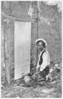 Fig. 42—Rug weaver at Cotahuasi. The industry is limited to a small group of related families, living in the Cotahuasi Canyon near Cotahuasi. The rugs are made of alpaca wool. Pure black, pure white, and various shades of mixed gray wool are employed. The result is that the rugs have “fast” colors that always retain their original contrasts. They are made only to order at the homes of the purchasers. The money payment is small, but to it is added board and lodging, besides tobacco, liqueurs, and wine. Before drinking they dip their finger-tips in the wine and sprinkle the earth “that it may be fruitful,” the air “that it may be warm,” the rug “that it may turn out well,” and finally themselves, making the sign of the cross. Then they set to work.