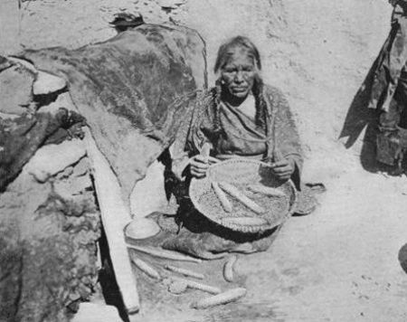An Oraibi Woman shelling Corn in a Basket of Yucca Fibre.